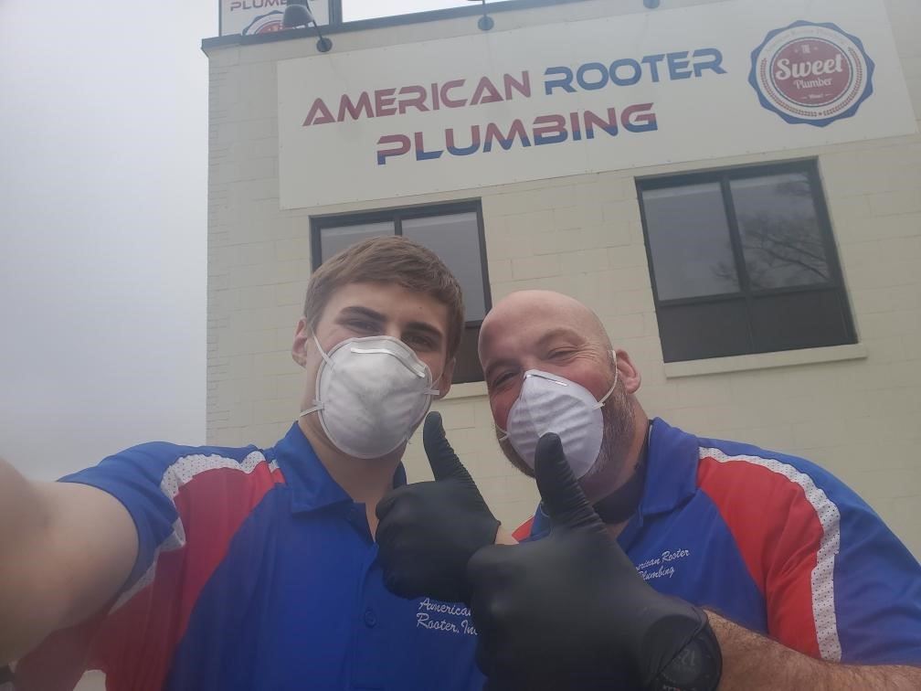 American Rooter workers posing with masks and gloves on the job