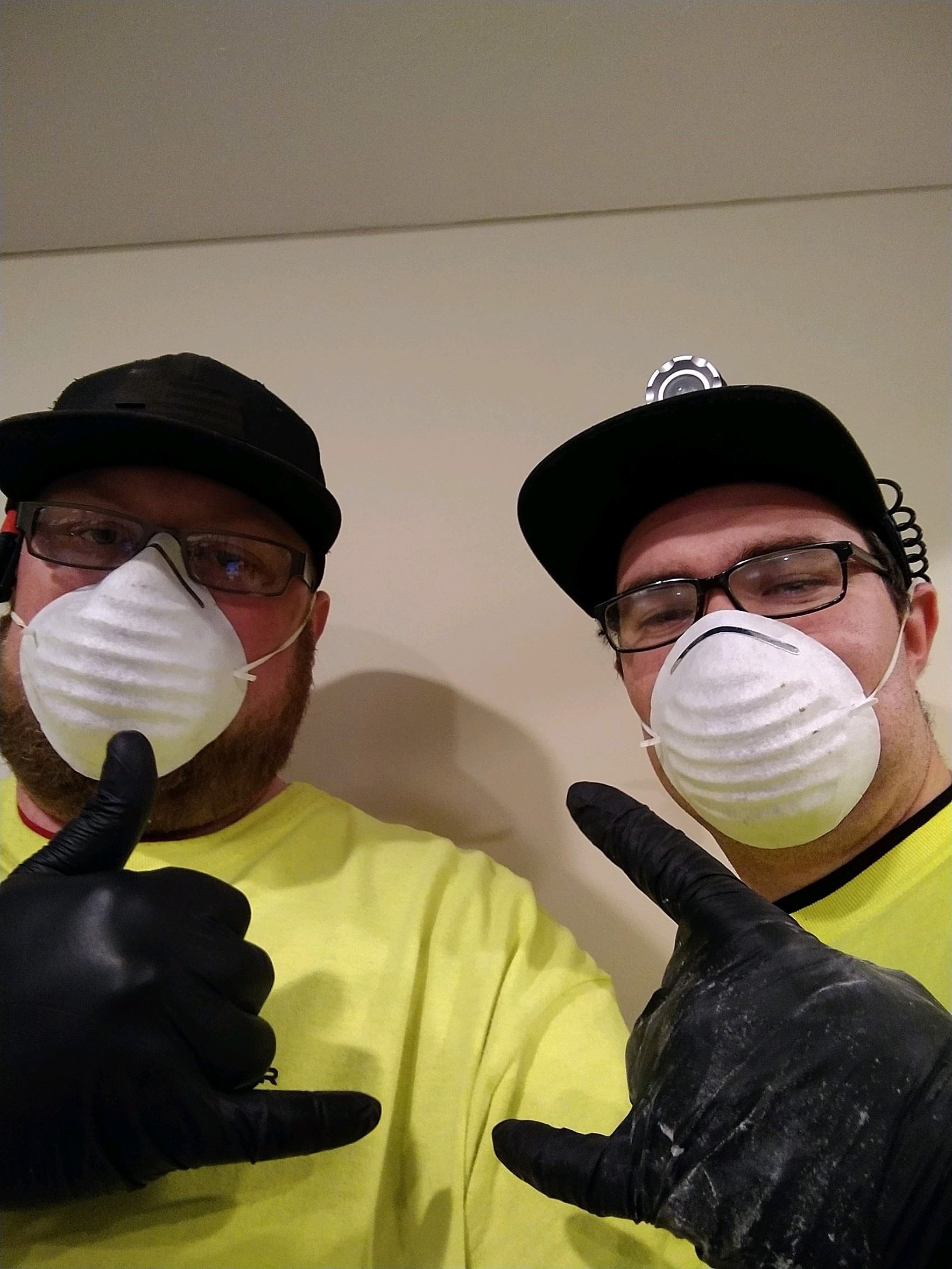American Rooter workers posing with masks and gloves on the job
