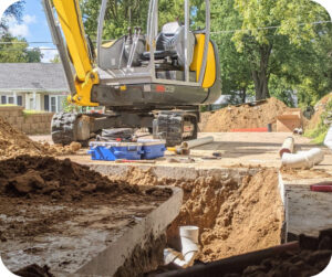 Compact excavator being used for digging and earthmoving during a plumbing project in Omaha.